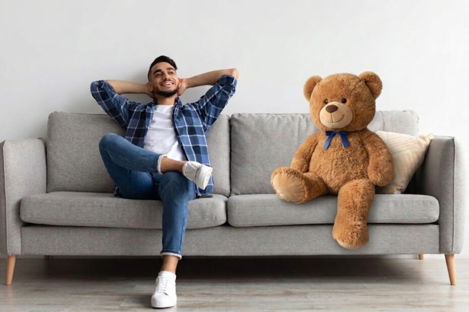 Man on a couch with a large teddy bear