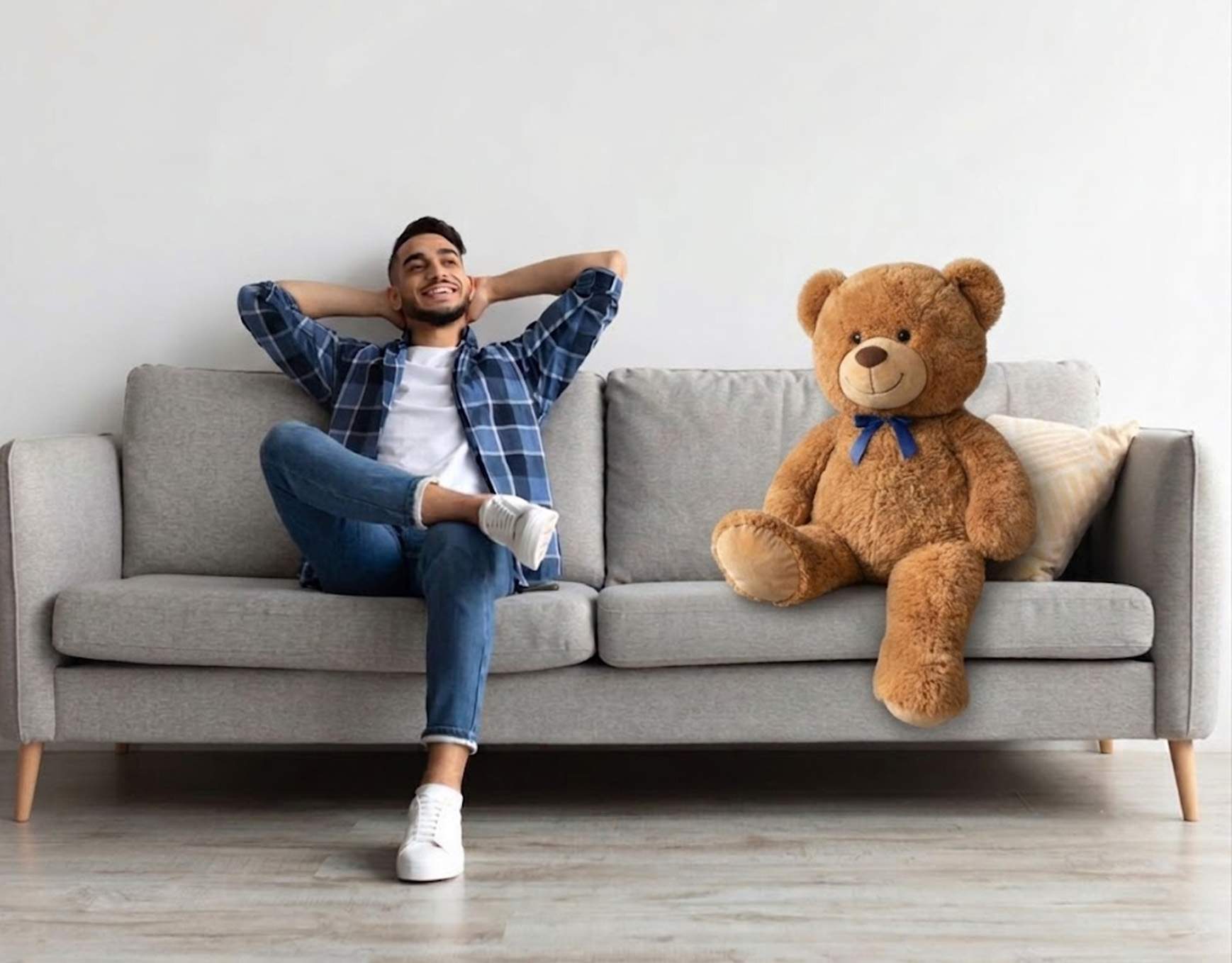 Man on a couch with a large teddy bear